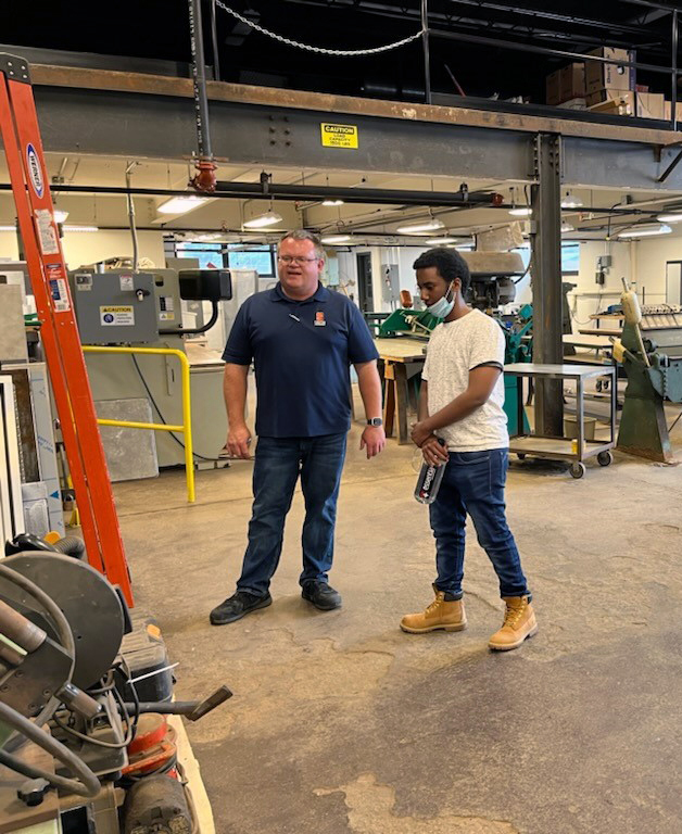 Craig Powers and Abdunasir Adam discuss work in the machine shop