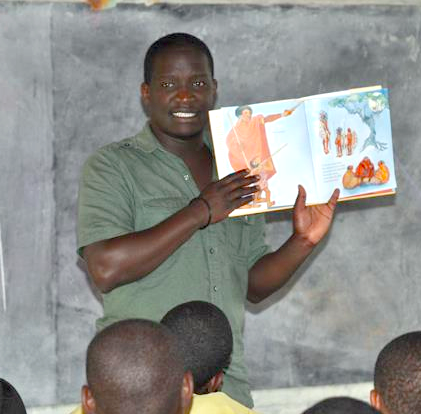 person holding a book in front of a classroom