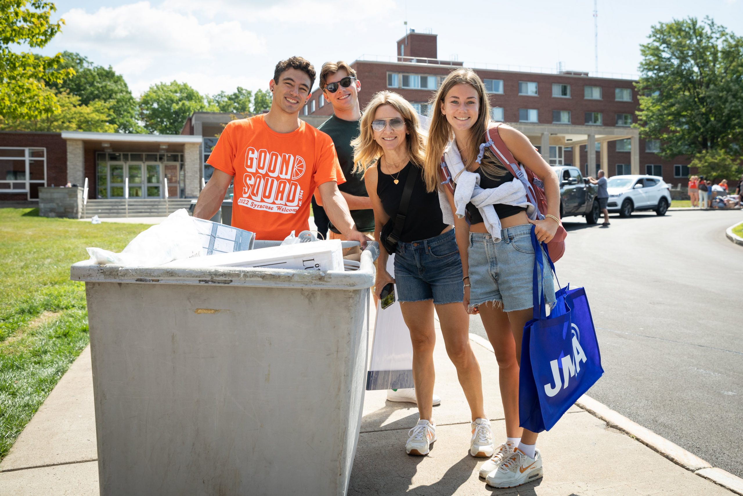 A member of the Goon Squad assists a student and their family with moving into their residence hall