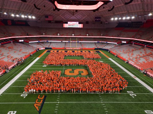 Syracuse University Class of 2026 form a large Block S on the field of the JMA Wireless Dome