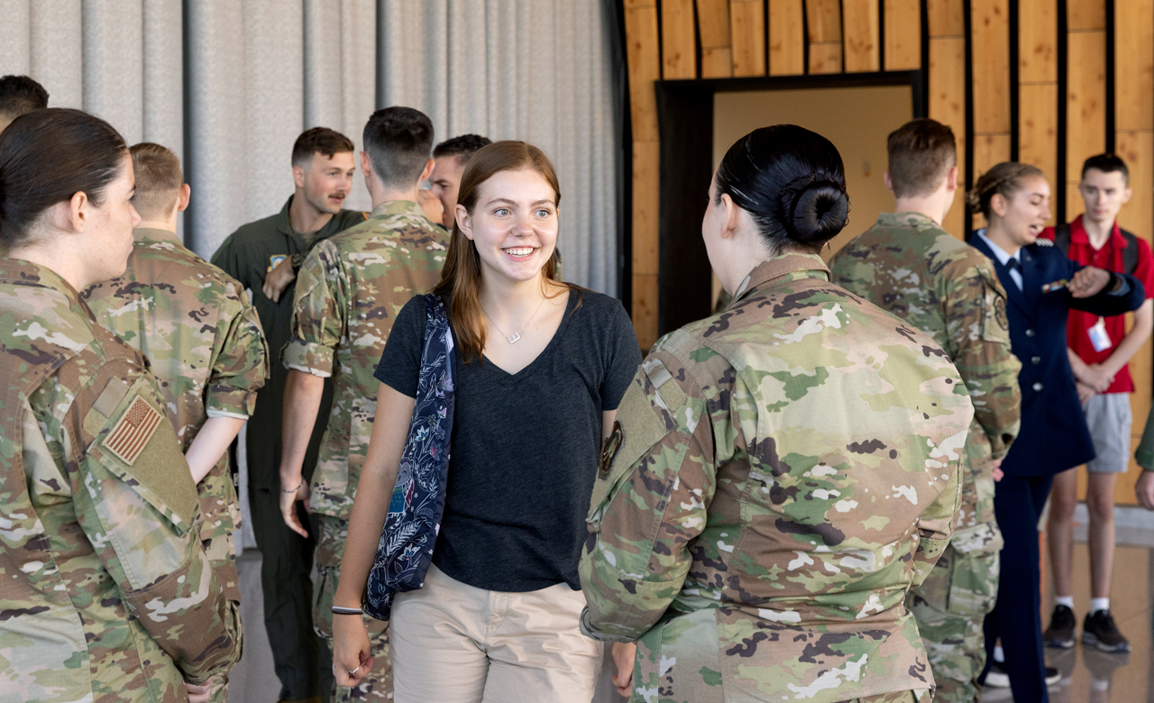 a group of students, including some in military uniform, mingle during Syracuse Welcome