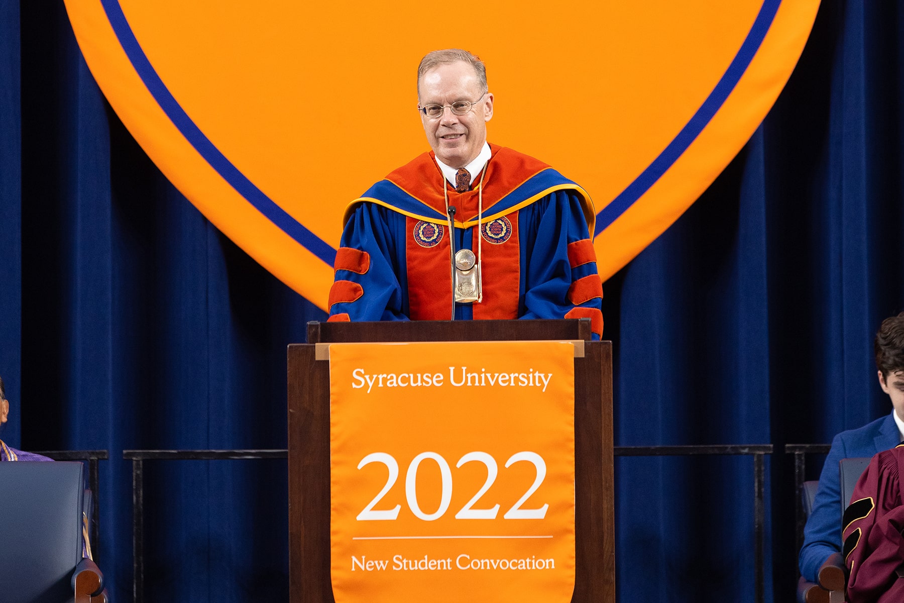 Chancellor Syverud, dressed in full regalia, speaks at the podium during 2022 New Student Convocation