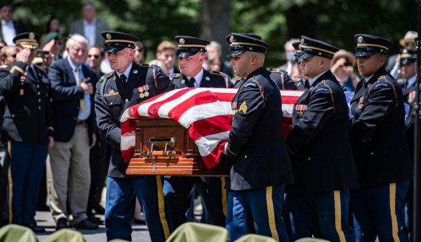 soldiers carrying casket in cemetery