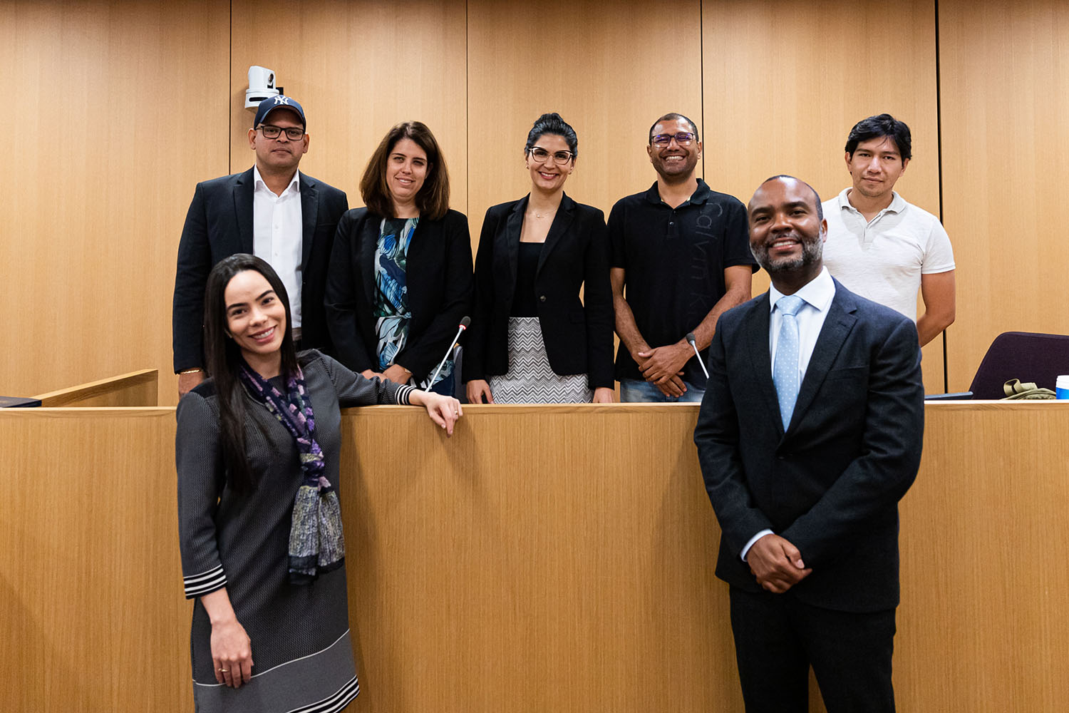 seven students from the English Language Institute's English for Lawyers cohort pose together in a court room setting