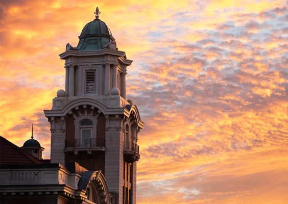 view of a sunset behind a view of Crouse College's steeple