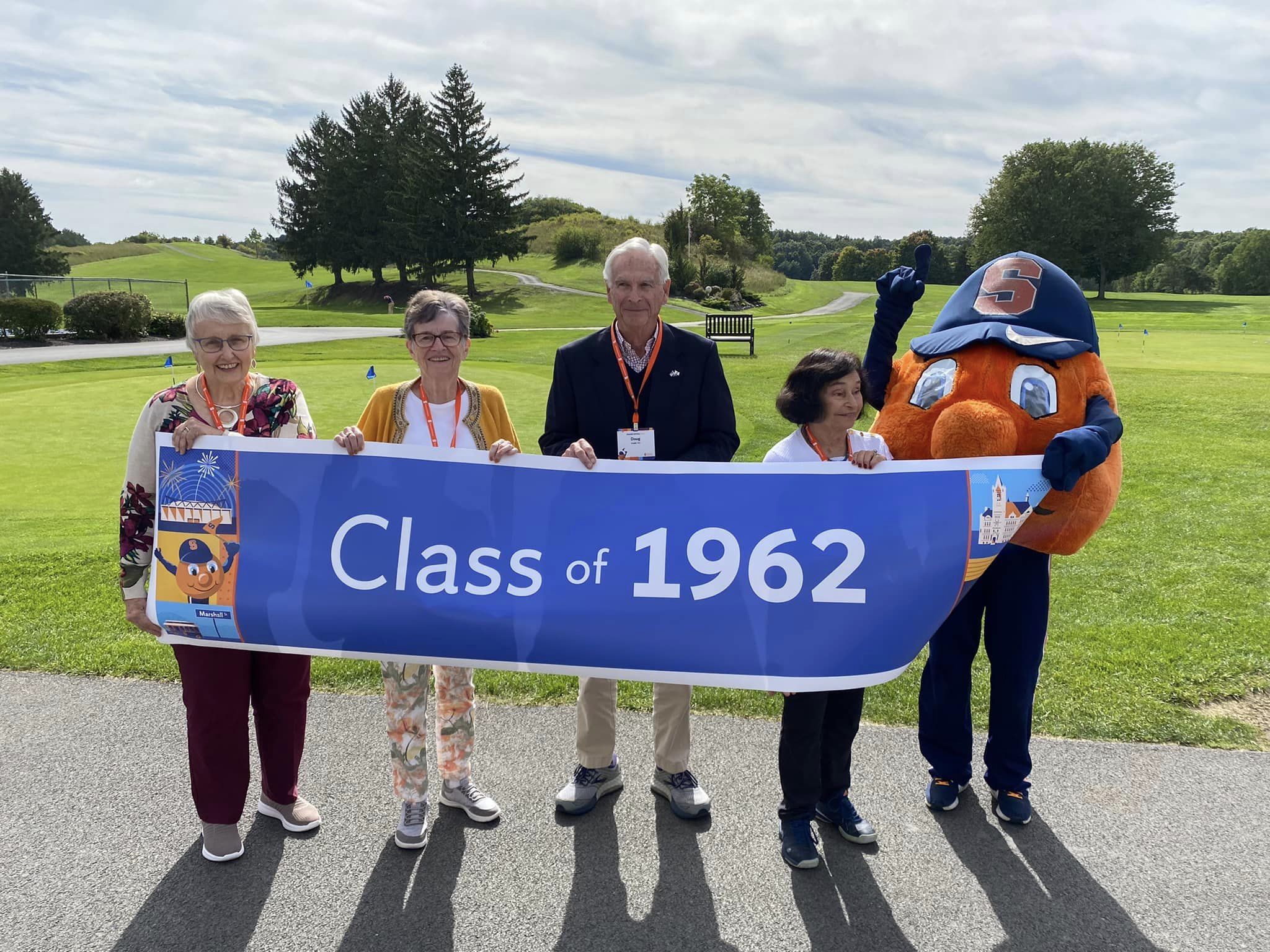 Alumni in the Class of 1962 pose with their class banner.