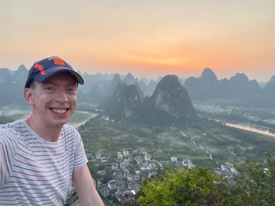 Evan Wichman '12 poses in front of the Li River in China