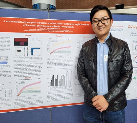 Yikang Xu in front of a poster describing his research project