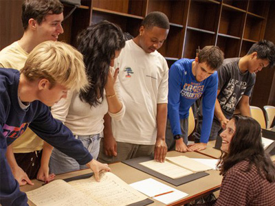 students in European Music Before 1800 class examine materials at the Special Collections Research Center