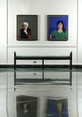 two portraits hanging above a bench