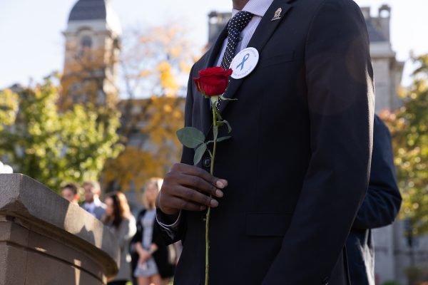 Individual holding a red rose.
