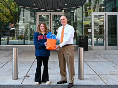 two people holding a swag bag in front of the Barnes Center