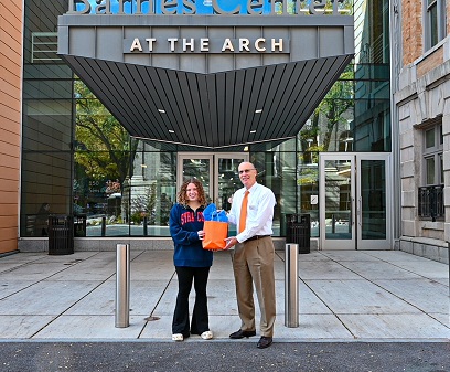 two people holding a swag bag in front of the Barnes Center