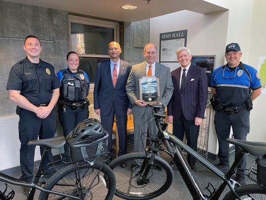 Staff from DPS and Student Experience pose with Jay Gelb and the electric bikes he donated to the Department of Public Safety