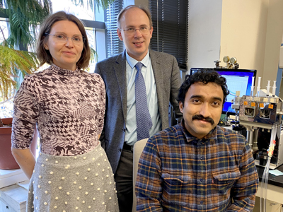 Three researchers pose in an office.
