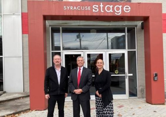 three people standing outside of Syracuse Stage