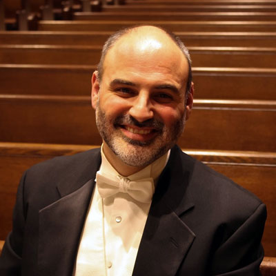 José Calvar smiling while seated in a church pew