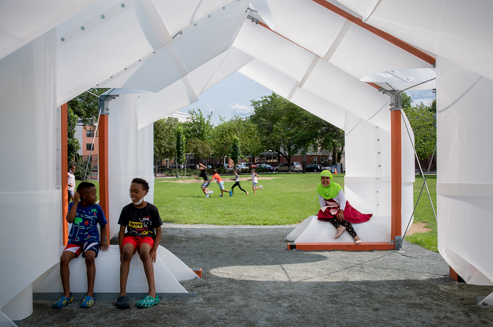 close-up view of the interior of the CloudHouse, a shade pavilion in Cambridge Massachusetts, with children sitting inside the structure 