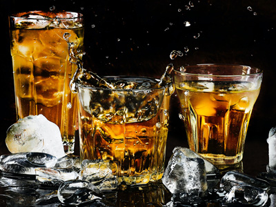 glasses of alcohol against a black backdrop