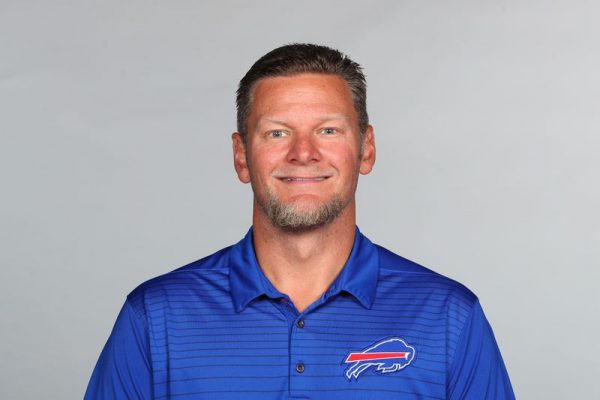 Man smiling with a Buffalo Bills polo on.