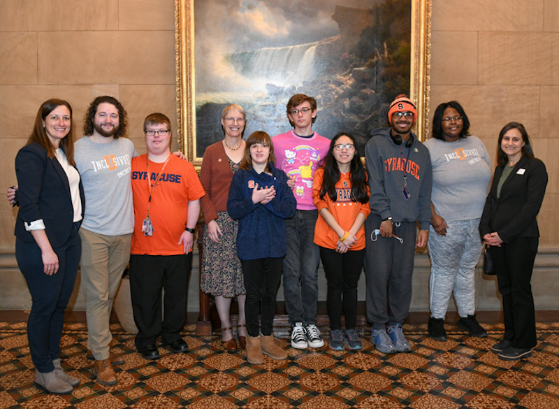 9 representatives from Syracuse University pose with State Senator Rachel May in Albany