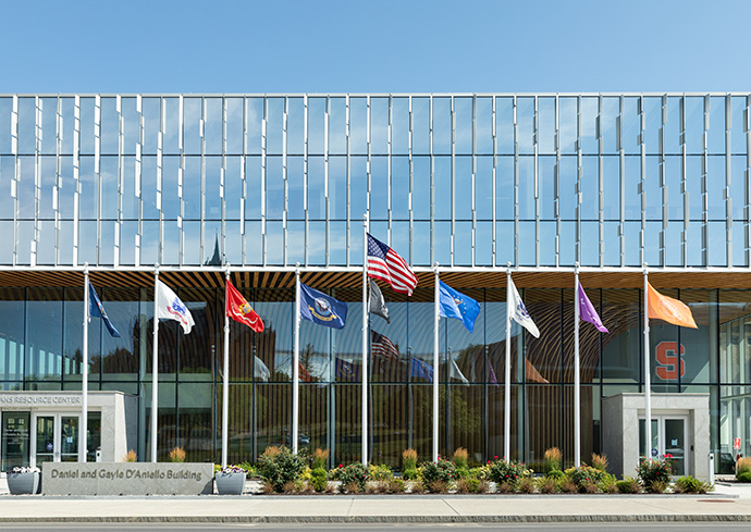 row of flags flying outside glass front building