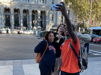 Students pose for a selfie outside.