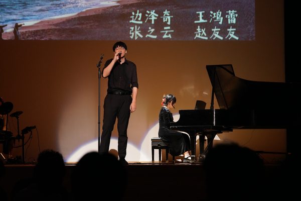 two students performing on stage, one on vocals and one on piano, during the CSSA Spring Festival Gala