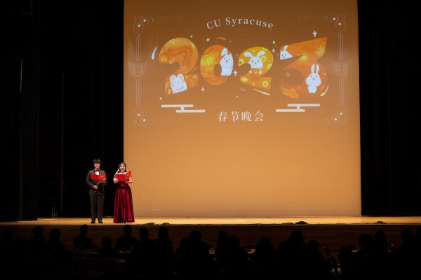two students in formal wear speak on stage during the Chinese Union Lunar New Year Celebration