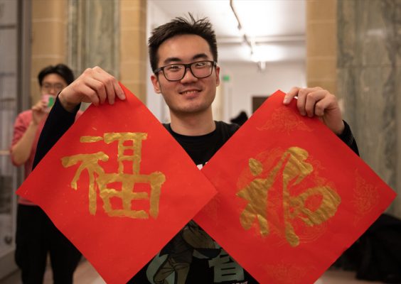 student holds up artwork done at the School of Architecture Chinese New Year Celebration