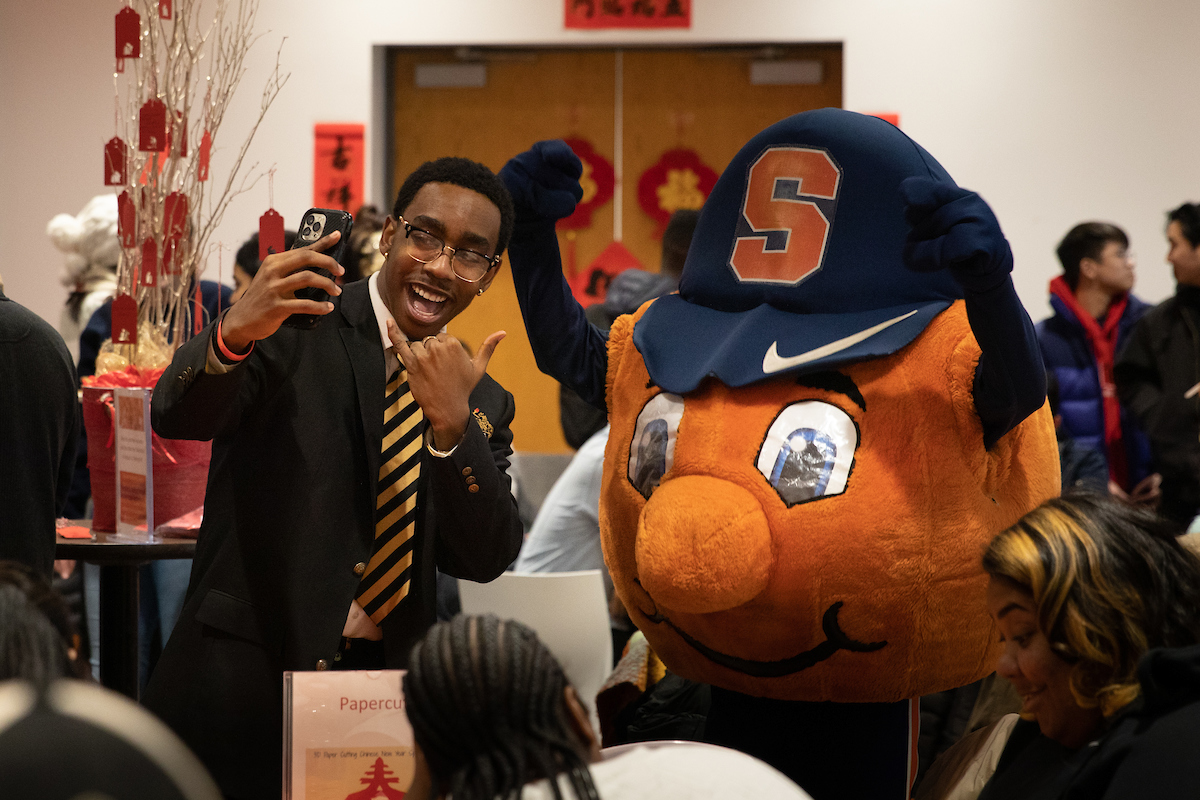 student takes a selfie with Otto at Chinese New Year Celebration
