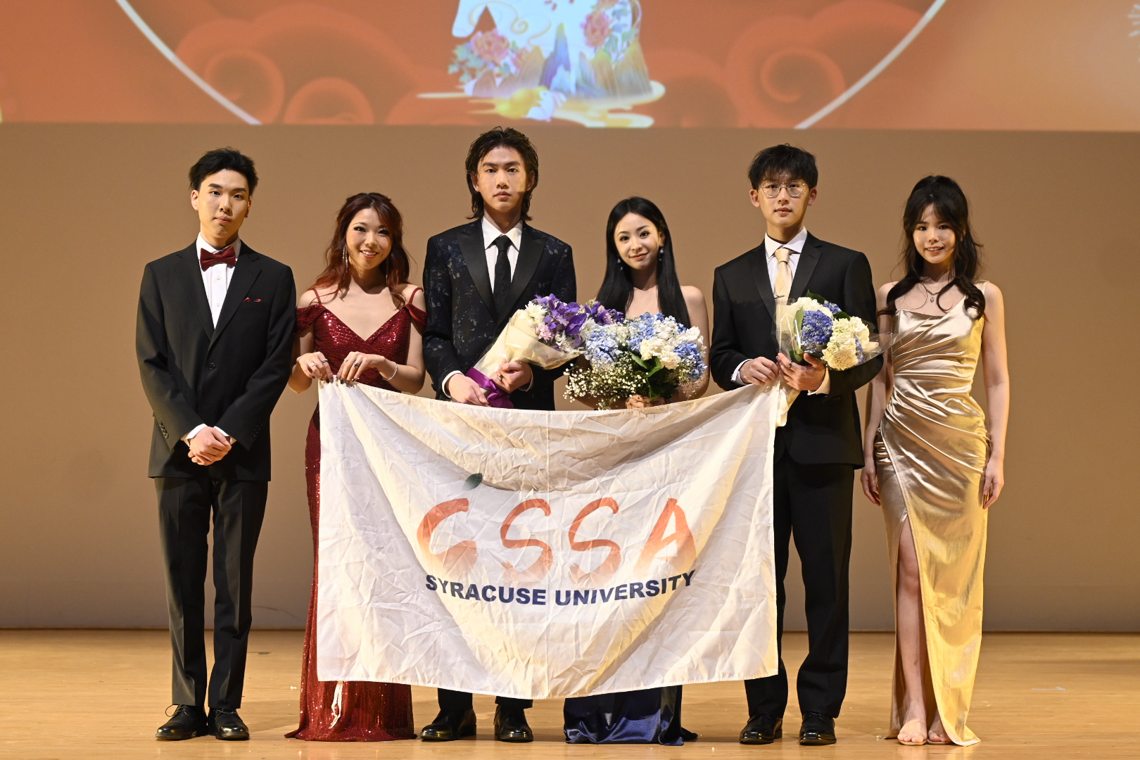 Members of the Chinese Student and Scholar Association pose with a banner that says "CSSA Syracuse University" at their Chinese New Year Gala