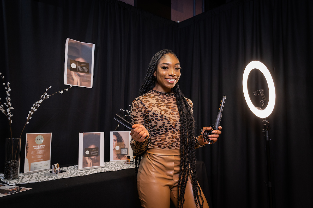 stylist holds up some of her hair equipment at the State of the Black Hair Experience event