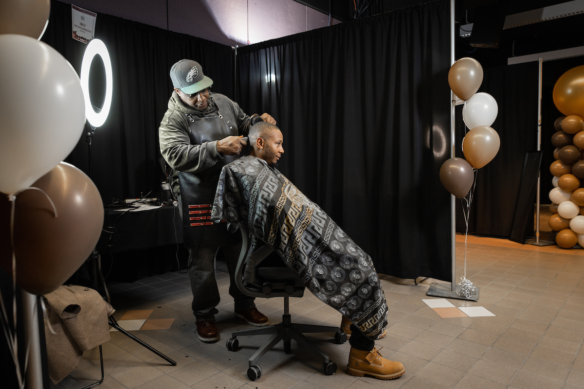 person receiving a haircut at the State of the Black Hair Experience event