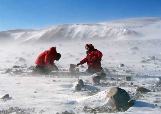two researchers collecting boulders from Milan Ridge in Antarctica
