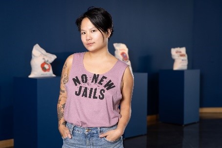 Stephanie Shih poses in a shirt that says "No New Jails"
