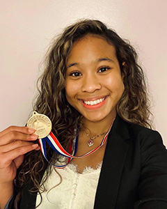Woman smiling holding a medal