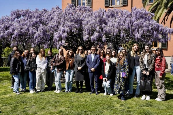 a large groups of students, faculty and staff pose outdoors with Mayor Dario Nardella in Florence, Italy