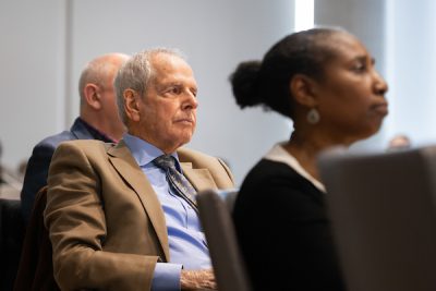 Man listening intently among audience at symposium