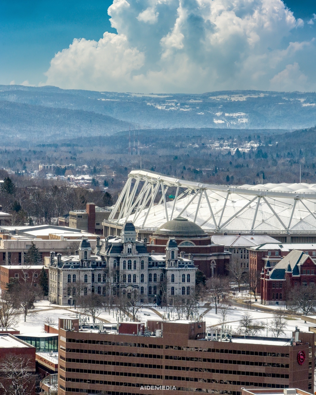 Arial view of campus with a light covering of snow and blue skies in the background.
