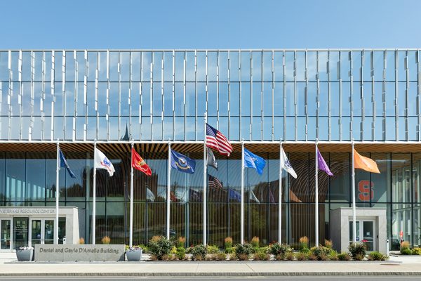 a series of flags in front of the National Veterans Resource Center at the Daniel and Gayle D’Aniello Building