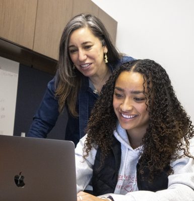 Khloe Gage works on a computer while Veteran Career Services Director Jennifer Pluta looks over her shoulder