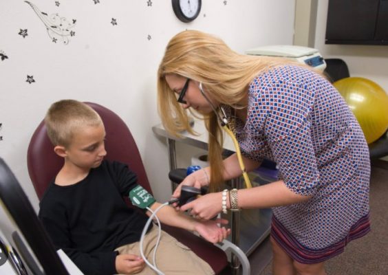 Woman taking child's blood pressure
