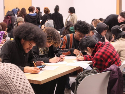Students at tables participating in writing workshop