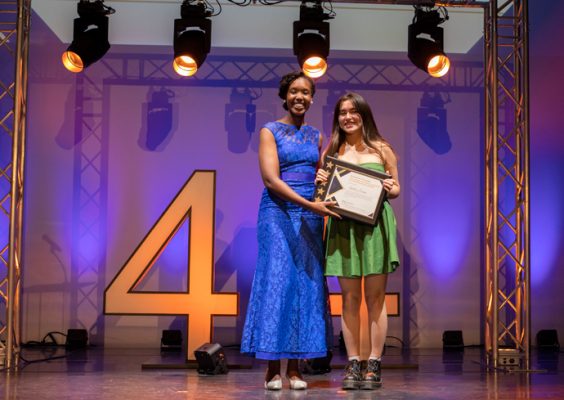 A Syracuse University staff member presenting the Award for Excellence by an Organization Leader to a Syracuse University student.