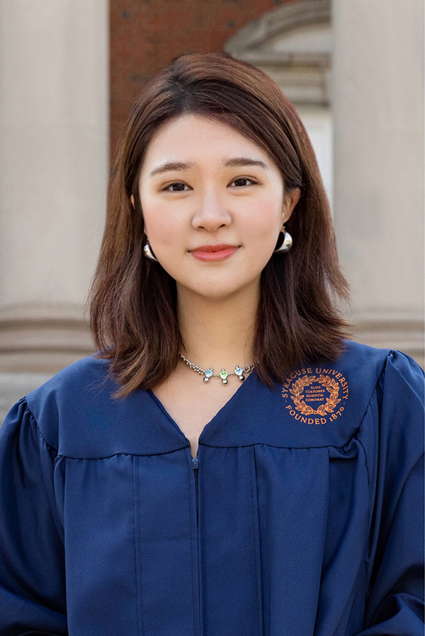 Ava Hu portrait outdoors wearing her Commencement gown