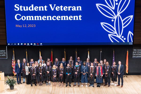 Large group of people standing on the stage during the student veteran commencement