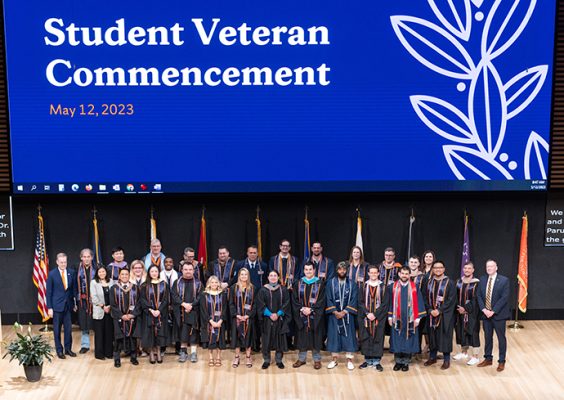 Large group of people standing on the stage during the student veteran commencement