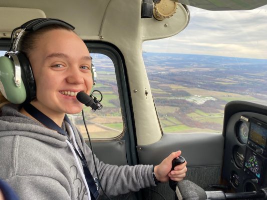 Emily Weaver poses in the cockpit of a plane