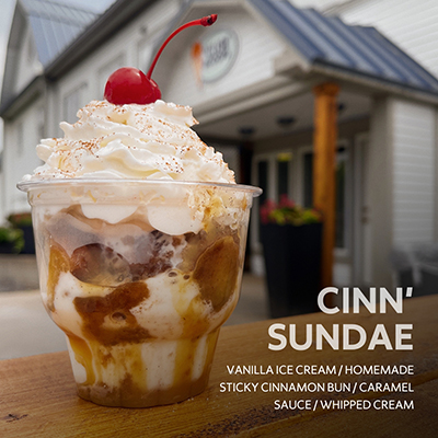 Cinn' Sundae featuring vanilla ice cream, homemade sticky cinnamon bun, caramel sauce and whipped cream.